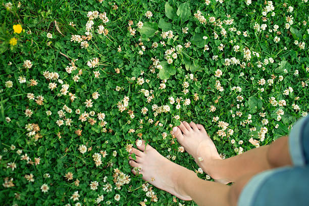 Bare feet walking on green grass in a park